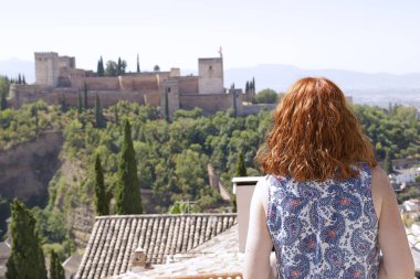 Granada, Spai 'de bulunan antik Arap kalesi Alhambra manzarasının keyfini çıkaran kadın.