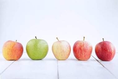 Beyaz arkaplana karşı farklı elma türleri satırı