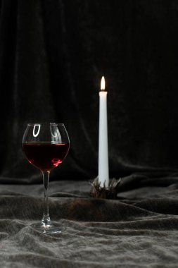 Bir kadeh kırmızı şarap ve bir mum.