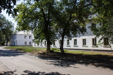 Ağaçların arkasında iki katlı beyaz evler..