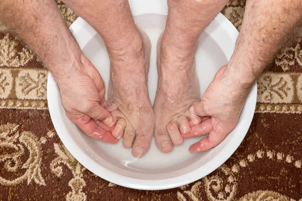 Foot washing in washbasin, Hammer toe feet.
