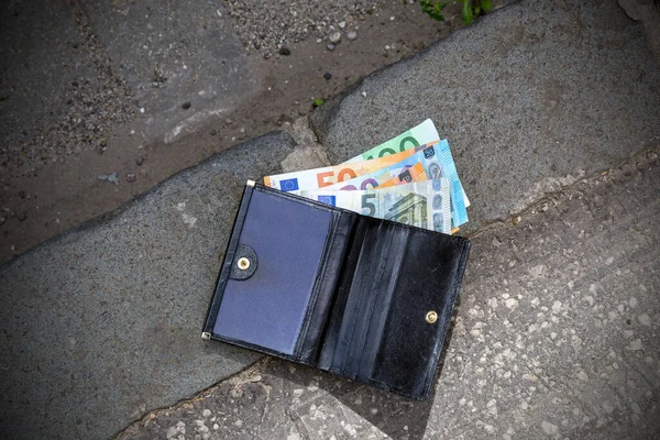 Lost wallet on the sidewalk, thrown, banknotes, euro.