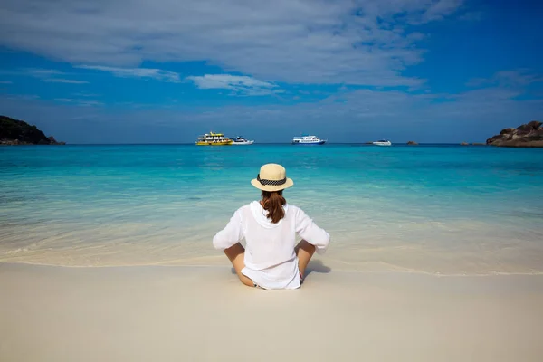 Issız bir tropik sahilde şapkalı bir genç güzel kadın. Gevşeme kavramı