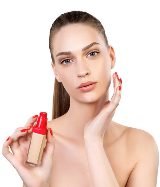 Beyaz arka plana sıvı temel uygulayan genç bir kadın.
