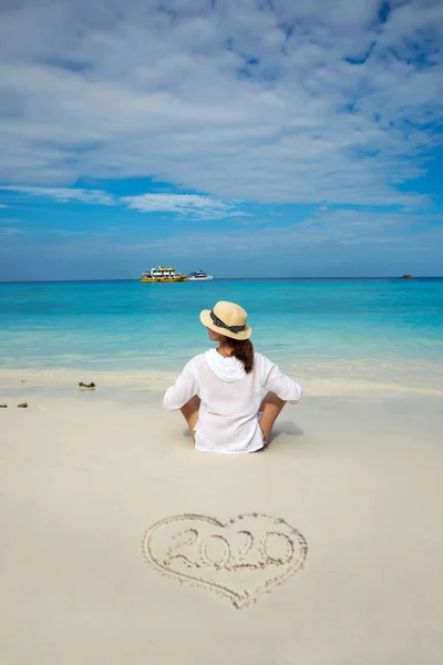 Genç kadın tropik bir plajda Yeni Yıl 2020 kutluyor