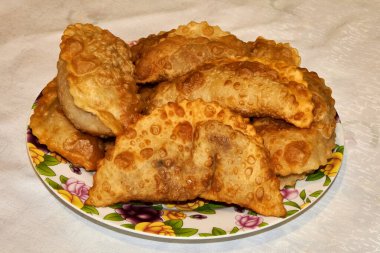 Büyük tabakta kızarmış cheburekler.