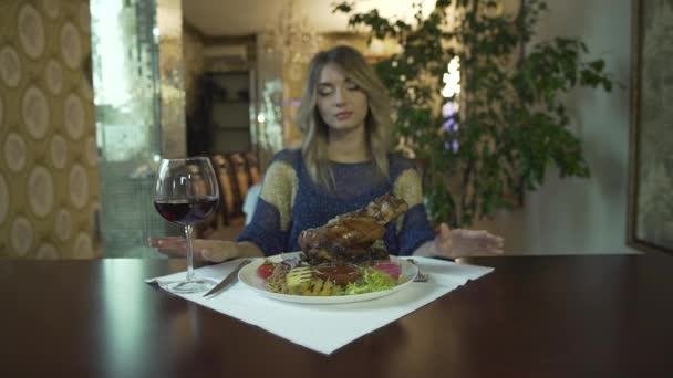 Krásná blondýna potetovaná mladá žena dívka čeká na jíst obrovský kus smaženého masa s rukama v luxusní restauraci