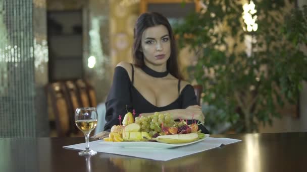 Jovem Sensual Morena Sedutora Vestido Preto Com Clivagem Comendo Frutas — Vídeo de Stock