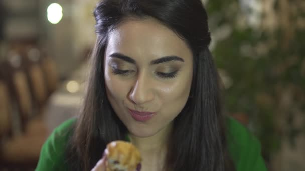 Attraktive brünette junge Frau verbraucht Puddinggebäck Dessert mit schmutzigen Händen in schickem Restaurant in Großaufnahme