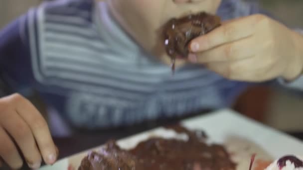 귀여운 소년이 초콜릿 디저트를 모습과 더러운 손으로 더러운 역겨운 식사를 — 비디오