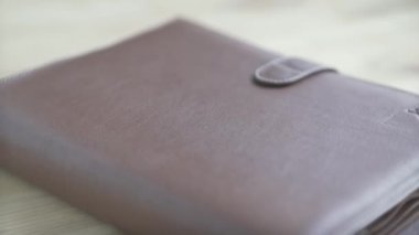 Güzel, kahverengi deri çanta taşıyıcısı not defteri kurşun günlük günlük alışkanlık planlayıcısı ahşap masa üzerinde.