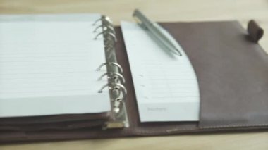 Güzel yakın çekim zarif açık kahverengi deri çanta defter günlük günlük planlama kurşun günlük ahşap masa