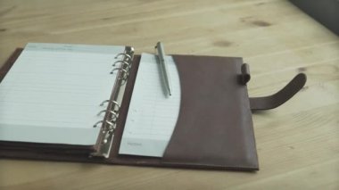 Güzel yakın çekim zarif açık kahverengi deri çanta defter günlük günlük planlama kurşun günlük ahşap masa