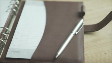 Güzel yakın çekim zarif açık kahverengi deri çanta günlük not defteri not defteri kurşun günlük ahşap masa