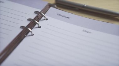 Boş beyaz kâğıt yakın çekim sayfa kurşun gazetecilik planlayıcı kahverengi deri defter ahşap masa üzerinde