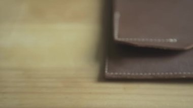 Yakın plan, gümüş top kalemini açık kahverengi deri deri defter kurşun günlük planlayıcısının üzerine koyuyor.