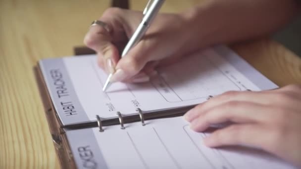 Zbliżenie Ujęcie Kobiet Ręce Pisanie Srebrnym Długopisem Brązowym Skórzanym Notatniku — Wideo stockowe
