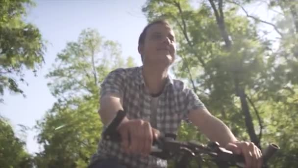夏日阳光明媚 穿着格子花衬衫 骑着慢悠悠的城市自行车 在空荡荡的街道上 从小到大 心平气和的中年人 — 图库视频影像