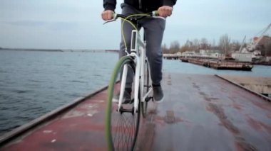 Genç sağlıklı bir adam akşam nehir manzarasında bisiklet sürüyor, aktif bir yaşam tarzı var.