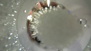 4K plastik bardağın içinden genç adamın üzerine daha fazla köpüklü soda döküp kapağını kapatıyor.