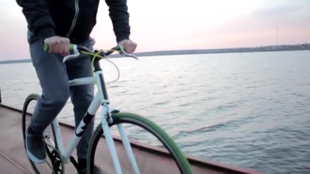 Jovem Homem Saudável Bicicleta Esportiva Pôr Sol Rio Rosa Noite — Vídeo de Stock