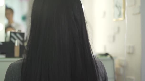 ファッションサロンで黒まっすぐ美しい髪に触れるプロの女性の美容師のスタイリストのビューを閉じます — ストック動画