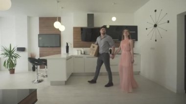 Mutlu ve heyecanlı genç bir çift mutfak içinde modaya uygun, modern tasarım 4K 'da yeni bir daireye taşınıyor.