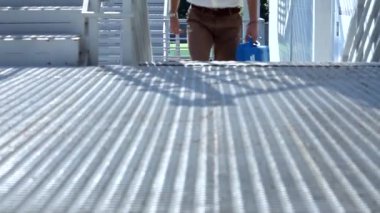 Beyaz gömlekli ve takım elbiseli yüksek güvenlikli, kurşun geçirmez pantolonlu koruma kılıfı olan adam binanın dışındaki modern merdivenlerden çıkıyor.