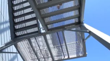 Alttaki kamera, binanın dışındaki modern mimari merdivenleri kullanarak takım elbiseli adamı 360 derece görüyor.