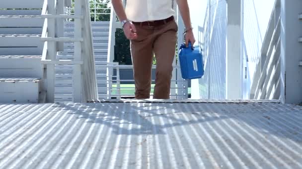 身穿西装 裤子和白衬衫 头戴高防弹衣的男子爬上大楼外的现代楼梯 — 图库视频影像