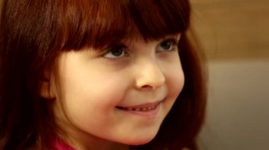 Sevimli, mutlu, küçük kız çocuğu. Kocaman hediye kutusuna bakıyor. Gülümsüyor, yakın çekim için bekliyor.