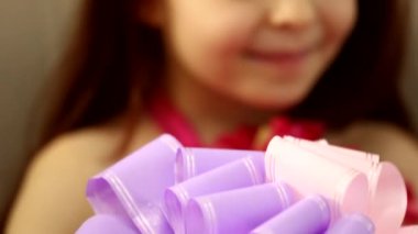 Sevimli, mutlu, küçük kız çocuğu. Kocaman hediye kutusuna bakıyor. Gülümsüyor, yakın çekim için bekliyor.