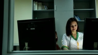 Genç profesyonel çekici bayan doktor gülümsüyor bilgisayar ekranını ofisteki küçük tatlı kıza gösteriyor.