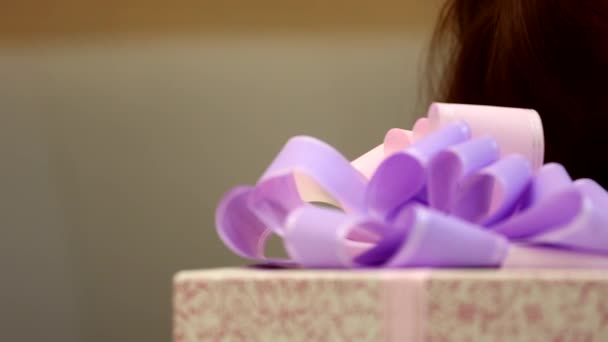 可爱的小女孩喜形于色 手里拿着一个巨大的礼品盒 包着紫色缎带的蝴蝶结 — 图库视频影像