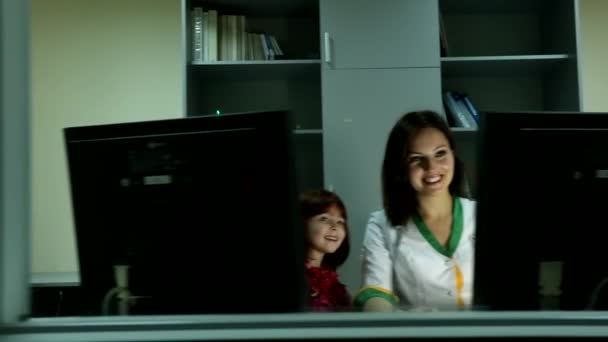 Güzel Genç Bayan Doktor Iki Bilgisayar Ekranının Arkasında Oturmuş Gülümsüyor — Stok video