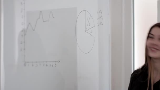 Glückliche Junge Gut Aussehende Mädchen Zeichnen Ein Diagramm Auf Weißem — Stockvideo