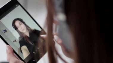 Güzel genç bayan siyah beyaz fotoğrafları izler ve çoklu dokunmatik tabletten siler.