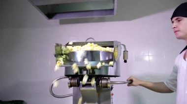 Siyah bandanalı beyaz erkek mutfak işçisi patlamış mısır otomatiğiyle çalışmak için bekliyor.