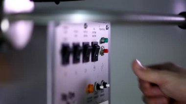 Otomatik patlamış mısır yapma makinesindeki küçük kırmızı düğmeye basarak kızarmış mısır yapan bir adamın yakın çekim görüntüsü.