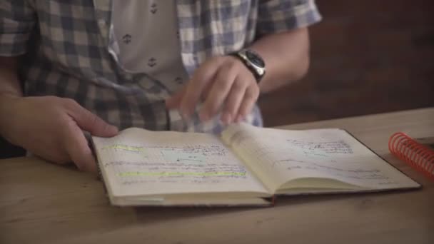 人工翻阅笔记本本日记本日记本规划员在大而轻的木制桌子上写了整整一页纸 — 图库视频影像