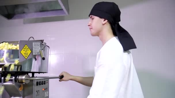 年轻迷人的白开化男性厨房工人 头戴黑色头巾 与爆米花自动售货机一起工作 — 图库视频影像