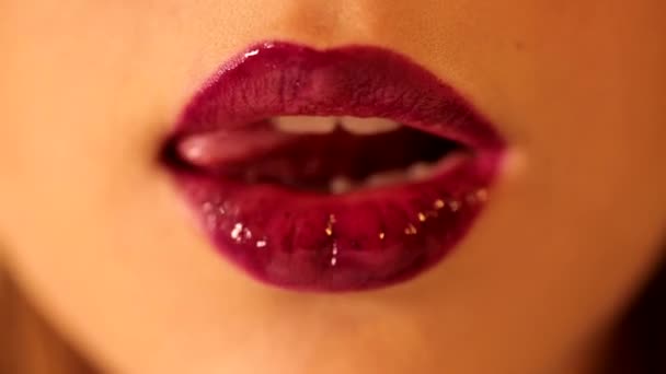 閉じるアップショットの魅力的な女性の舌なめる彼女の唇とともに明るい深い赤い梅のベリー光沢のある口紅ティントリップグロス — ストック動画