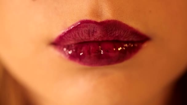 魅力的な女性の舌なめる彼女の唇とともに明るい深い赤梅ベリー光沢のある口紅Tint Lipgloseでクローズアップショット — ストック動画