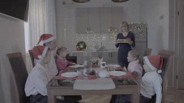 Mutlu, heyecanlı altı kişilik aile Noel yemeğinin tadını çıkarın. Noel Baba şapkalarının içinde muhteşem bir mutfak kutlaması atmosferinde.