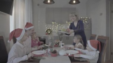 Sevimli, mutlu, heyecanlı, altı kişilik bir aile, Noel yemeğini, şenlikli, rahat bir mutfakta kutluyor.