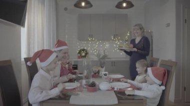 Heyecanlı, mutlu, mutlu, altı kişilik bir aile, Noel yemeğini, şenlikli atmosfer sıcacık mutfağında kutluyor.