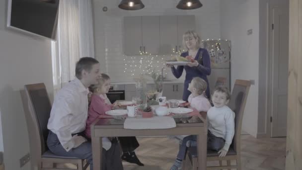 可愛いです幸せな4人の子供家族祝います新年イブオンキッチンテーブル父息子娘笑い母親サービス — ストック動画