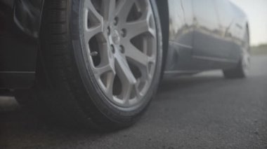 Siyah tekerlek yakın çekim lüks premium kalite spor yarış yeni araba asfaltta tam hızda başlıyor