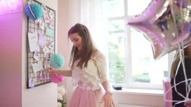 Güzel elbiseli, renkli balonlu ve mutlu üç çekici genç kadın doğum günü partisi dansını kutluyor.