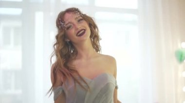 Profesyonel çekici ve güzel bir kadın model süslü elbiseler içinde Pastel Light Güzellik Salonu 'nda yavaşça yürüyor.
